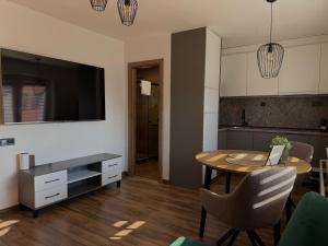 a kitchen and dining room with a table and a television at IQ Apartments in Prešov