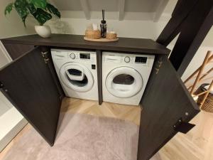 a washer and dryer under a counter in a room at Cosy apartment with garden in Kortrijk