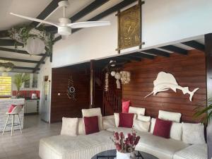 a living room with a couch and a ceiling fan at VILLA ZEN in Sainte-Anne