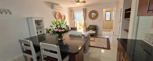 a kitchen with a table with a vase of flowers on it at Sandstone - 2 x Bedroom Apartment! in Knysna