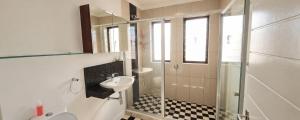 a bathroom with a sink and a glass shower at Sandstone - 2 x Bedroom Apartment! in Knysna +9 photos