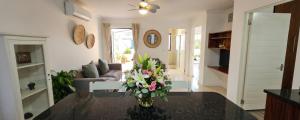 a living room with a vase of flowers on a table at Sandstone - 2 x Bedroom Apartment! in Knysna