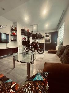 a living room with a glass table and a motorcycle at Apartment klein, fein, ruhig und gemütlich in Bochum