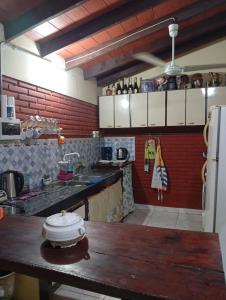 a kitchen with a wooden table and a refrigerator at Posada El Descanso in Caacupé