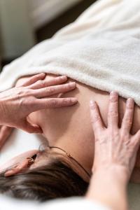 a woman laying on a bed with a towel on her face at Villa Grand Maur in Spa