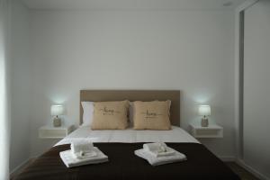 a bedroom with a bed with two towels on it at Refúgio de Ferrel in Ferrel