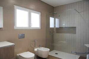 a bathroom with a shower and a toilet and a sink at Refúgio de Ferrel in Ferrel +21 photos