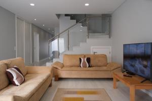 a living room with two couches and a staircase at Refúgio de Ferrel in Ferrel