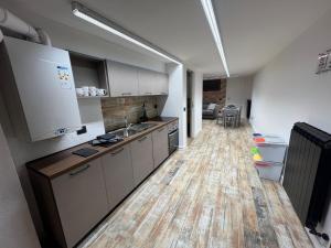 a kitchen with white cabinets and a wooden floor at Mini Suite Apartment 2 in Castel di Sangro