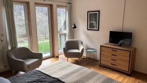a bedroom with a bed and a television and a chair at Haus Moselliebe B&B in Ediger-Eller