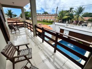 a balcony with a bench and a view of the water at Beach House Sao Jose in São José da Coroa Grande