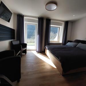 a bedroom with a bed and two windows at Haus Moselliebe B&B in Ediger-Eller