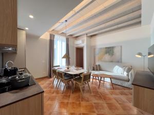 a kitchen and living room with a table and a couch at Castello Belvedere Apartments in Desenzano del Garda