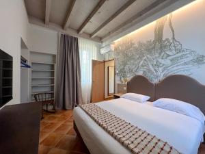 a bedroom with a large bed and a painting on the wall at Castello Belvedere Apartments in Desenzano del Garda +57 photos