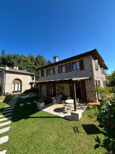 a large stone house with a patio and a yard at Ca Malfer in Costermano sul garda
