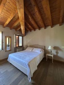 a bedroom with a large bed in a room with wooden ceilings at Ca Malfer in Costermano sul garda
