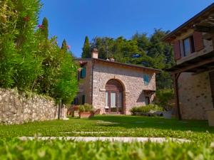 a large stone house with a yard with green grass at Ca Malfer in Costermano sul garda +12 photos
