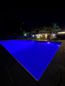 a swimming pool at night with blue illumination at El Charanguito Casa Quinta in Capilla del Señor