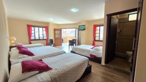 a bedroom with two beds with purple pillows at Hotel Vilcabamba Eterna Juventud in Vilcabamba