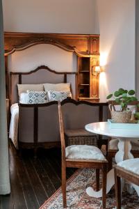 a bedroom with a bed with a table and a table at Villa Grand Maur in Spa