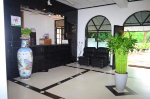 una sala d'attesa con un grande vaso e piante di Jayasinghe Holiday Resort a Kataragama