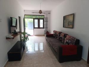 a living room with a couch and a table at Golden Leaf house in Weligama