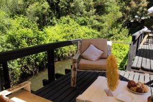 a chair sitting on a deck with a table at Estero El Claro Hotel y Cabañas in Pucón