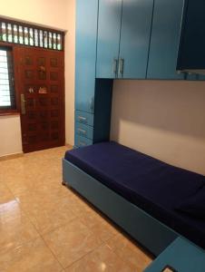 a bedroom with a bed with blue cabinets and a door at Golden Leaf house in Weligama