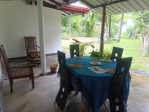 a table with chairs and a blue table cloth on it at Golden Leaf house in Weligama