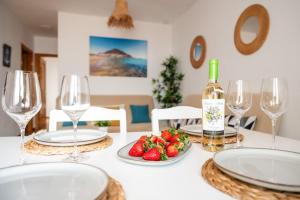 a table with wine glasses and a plate of strawberries at El Velero - Vacaciones inolvidables frente el MAR in San José