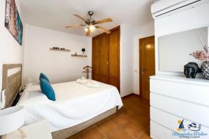 a small bedroom with a bed and a ceiling fan at El Velero - Vacaciones inolvidables frente el MAR in San José