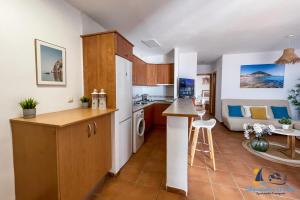 a kitchen and a living room with a couch at El Velero - Vacaciones inolvidables frente el MAR in San José