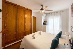 a bedroom with a bed and a ceiling fan at El Velero - Vacaciones inolvidables frente el MAR in San José