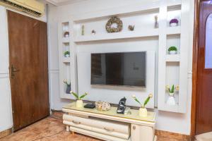 a living room with a tv on a wall at The 4 Kays Apartment - One Bedroom in Agege +2 photos