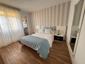 a bedroom with a bed with a striped wall at Torkes in Foz