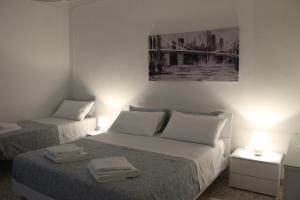 a bedroom with two beds and a painting on the wall at Felicia in Bisceglie
