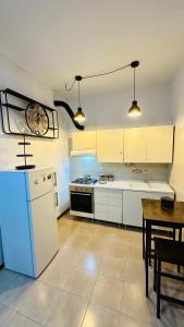 a kitchen with a white refrigerator and a table at Esclusive Spa Suite in Comacchio
