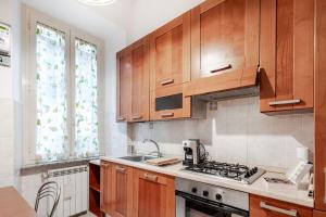 a kitchen with wooden cabinets and a stove top oven at Residenza Torre Antica - Nel Cuore di Viterbo in Viterbo