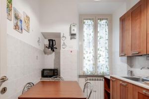 a kitchen with a table and a sink and a window at Residenza Torre Antica - Nel Cuore di Viterbo in Viterbo +3 photos