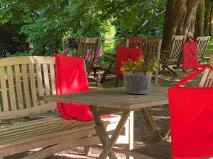 eine Holzbank mit einem Picknicktisch und roten Servietten in der Unterkunft Hotel Grander Mühle in Kuddewörde