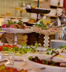ein Buffet mit vielen Tellern mit Speisen auf einem Tisch in der Unterkunft Hotel Grander Mühle in Kuddewörde