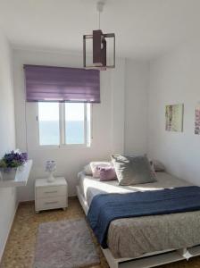 a bedroom with a bed and a window at Apartamento en primera línea de la playa a 15 minutos de la Ciudad de Valencia in Valencia