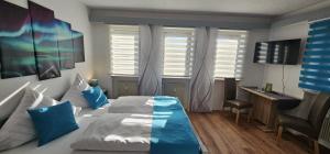a bedroom with a bed with blue pillows and a desk at Stadtblick Bischofsheim in Bischofsheim an der Rhön
