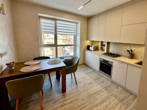 a kitchen with a table and chairs and a dining room at Центр стадіон Central Сity Замкова in Rivne
