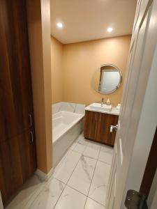 a bathroom with a tub and a sink and a mirror at Appartement sur deux niveaux in Quebec City +51 photos