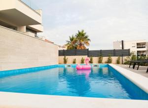a pink flamingo in the swimming pool of a house at Villa Poseidon in Novalja