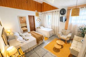 a bedroom with a bed and a chair in a room at Pousada Surf na Guarda in Guarda do Embaú