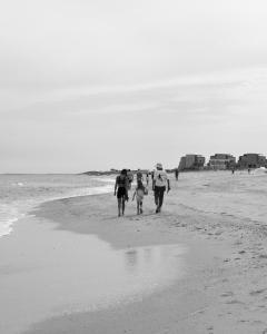 a group of people walking on the beach at Amina Wind Resort by Tasman in Salinas +57 photos