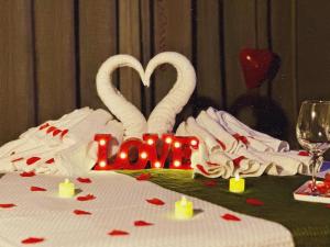 a table with two white swans and a love sign at Pousada All Green - Monte Verde in Monte Verde +68 photos