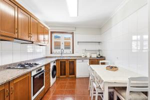 a kitchen with wooden cabinets and a table and a counter at Vale do Vez in Arcos de Valdevez